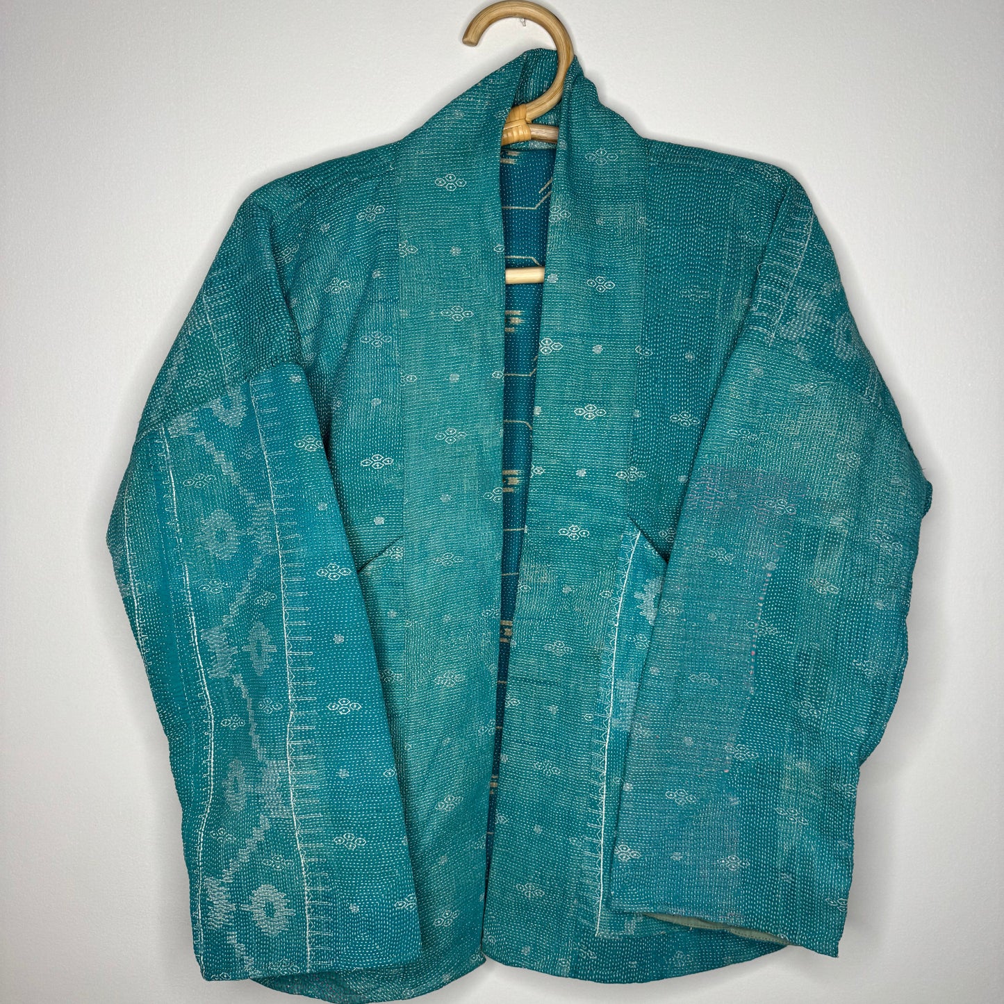 Kantha jacket against a white wall