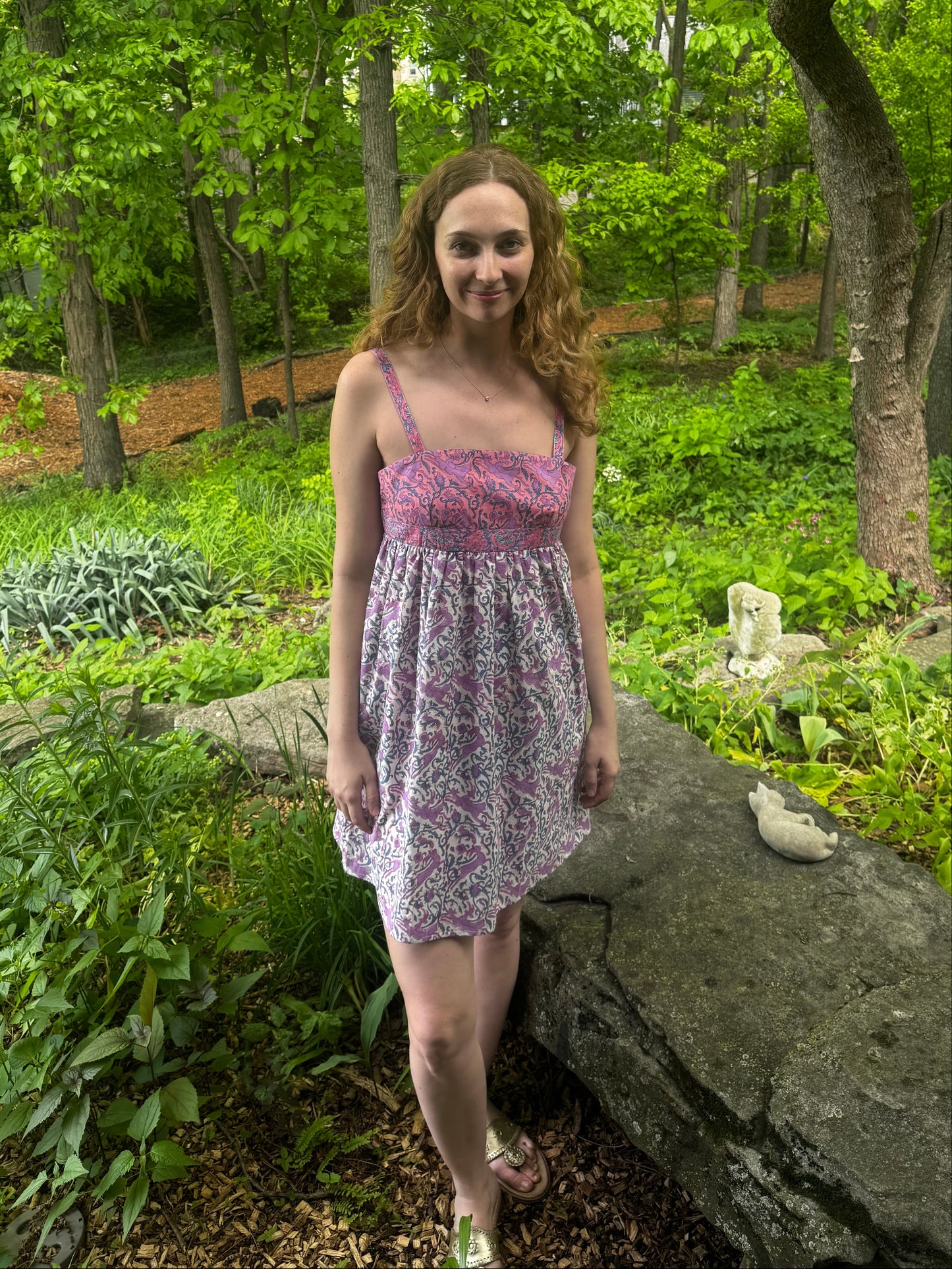 Person standing in a forest with trees and greenery around