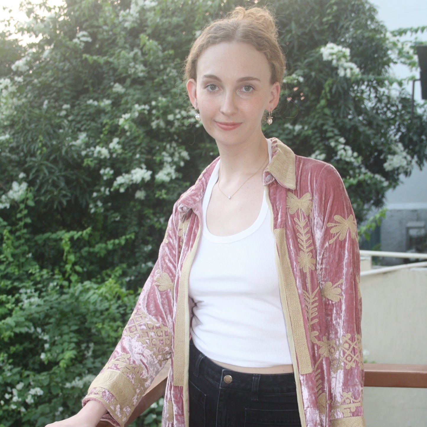Woman wearing a traditional outfit with a floral pattern in an outdoor setting