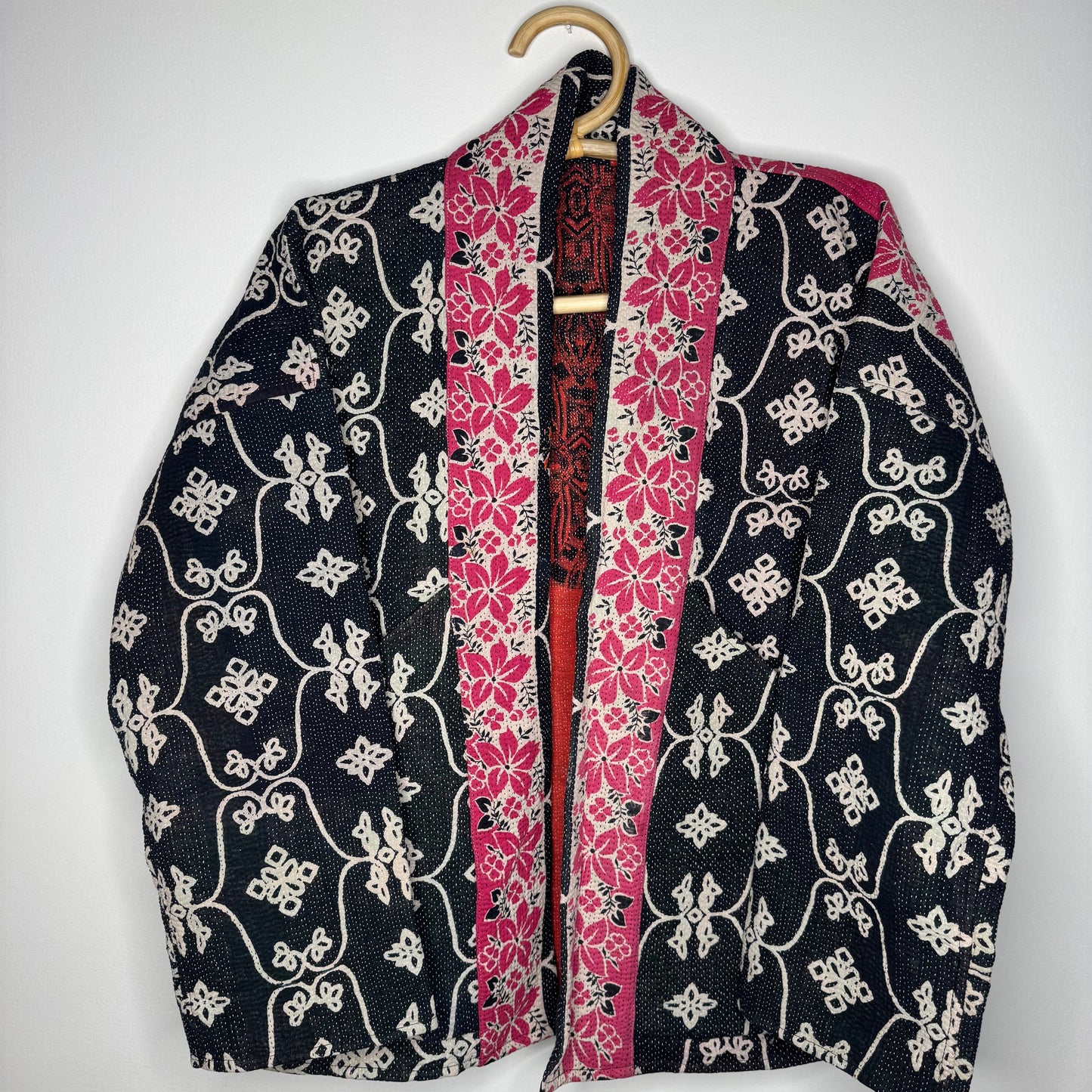 Kantha jacket against a white wall
