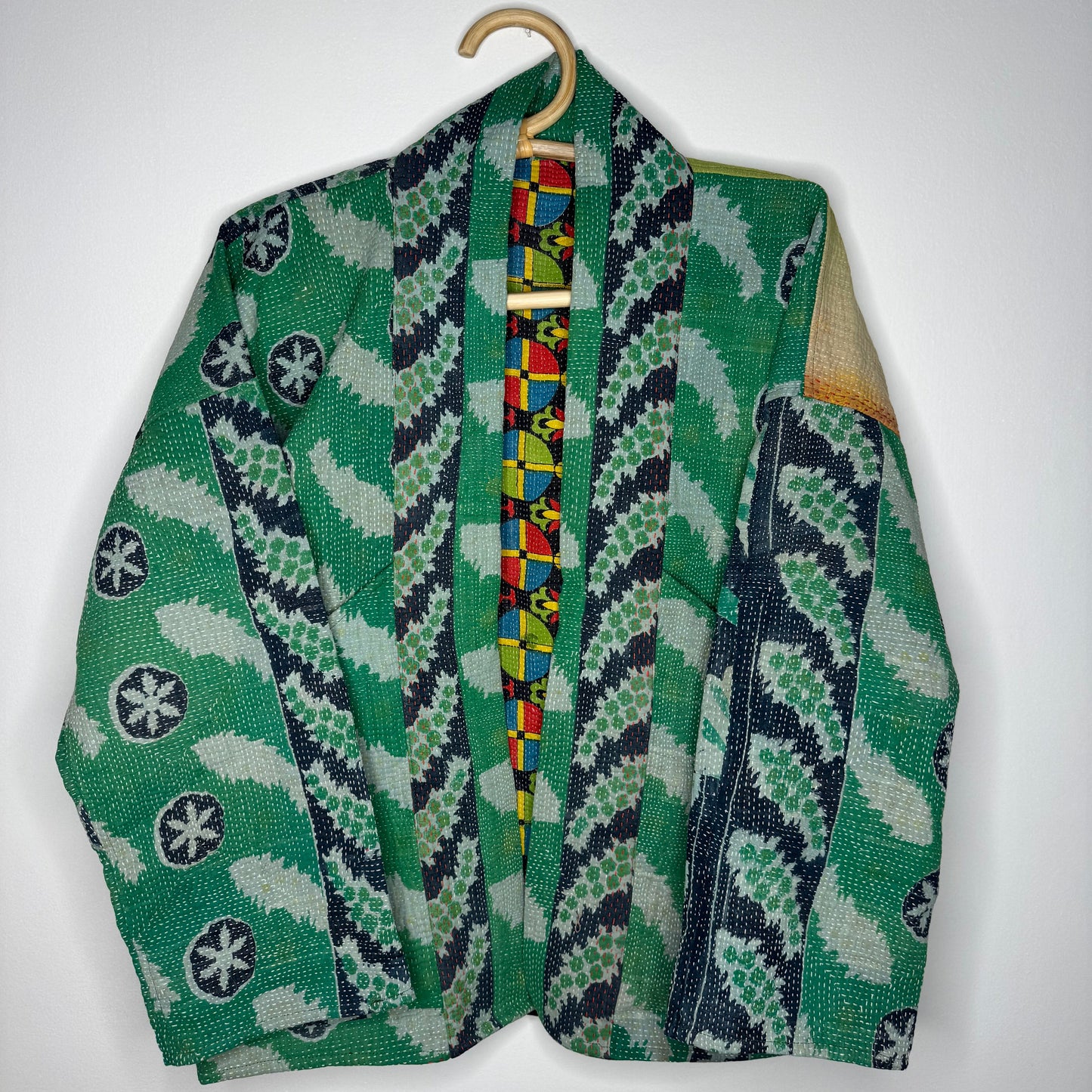 Kantha jacket against a white wall