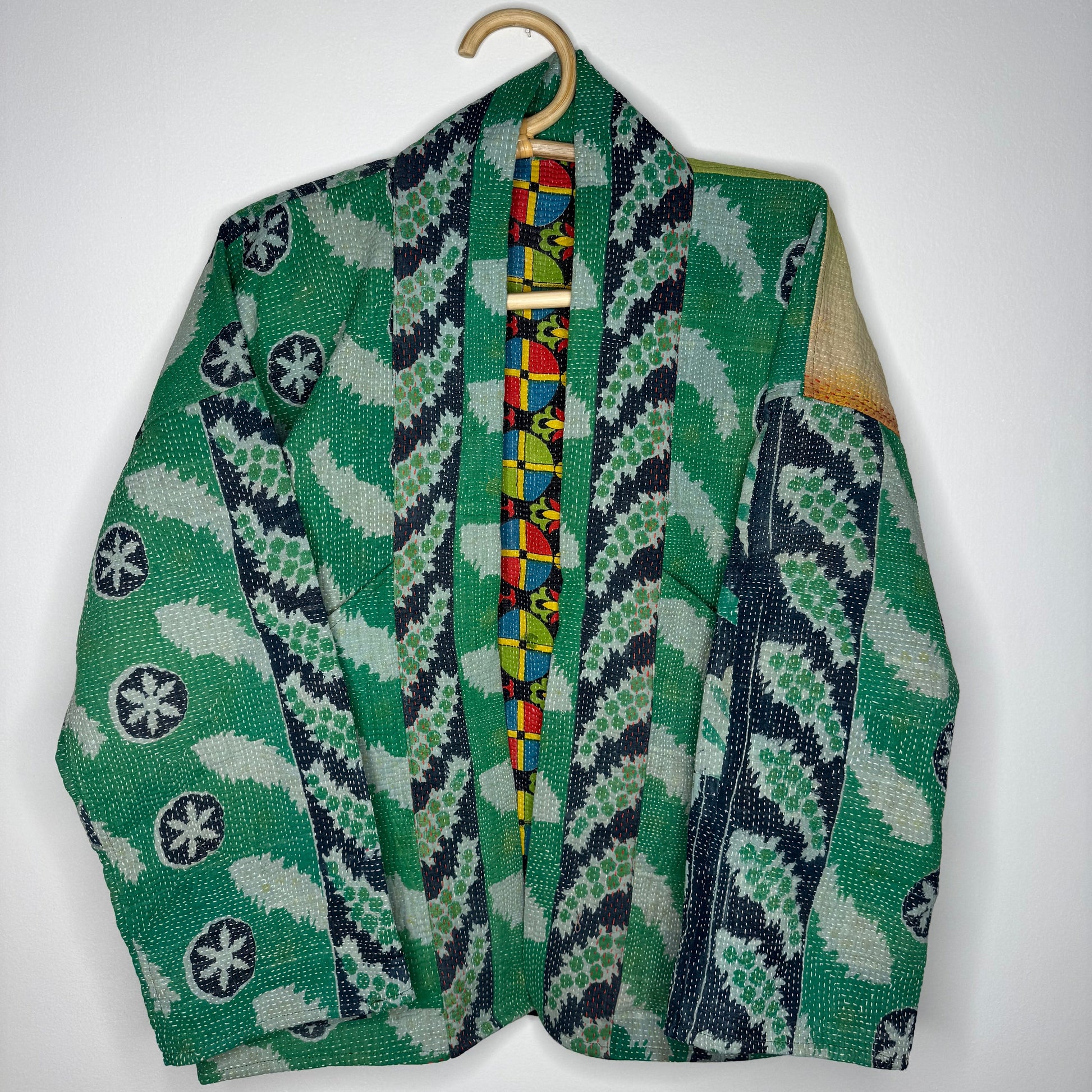 Kantha jacket against a white wall