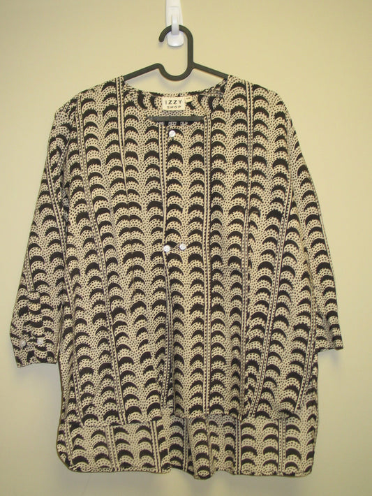 Patterned tunic on a hanger against a beige background. 