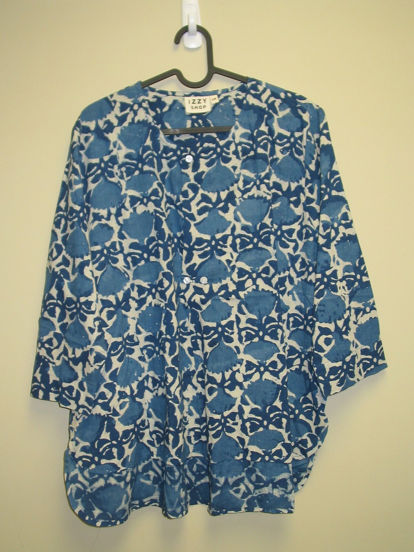 Blue and white patterned tunic on a beige background