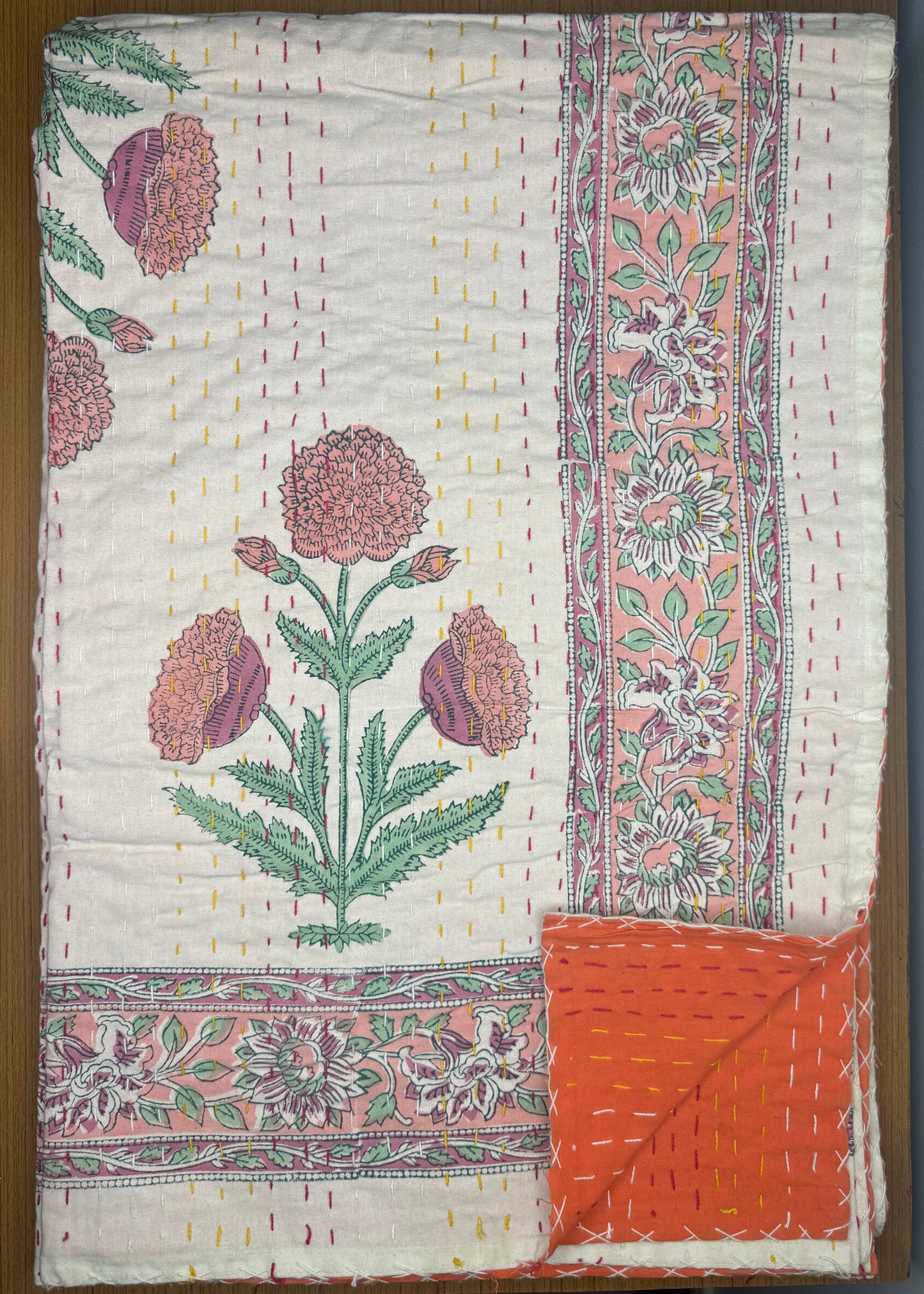 Floral patterned quilt on a wooden surface
