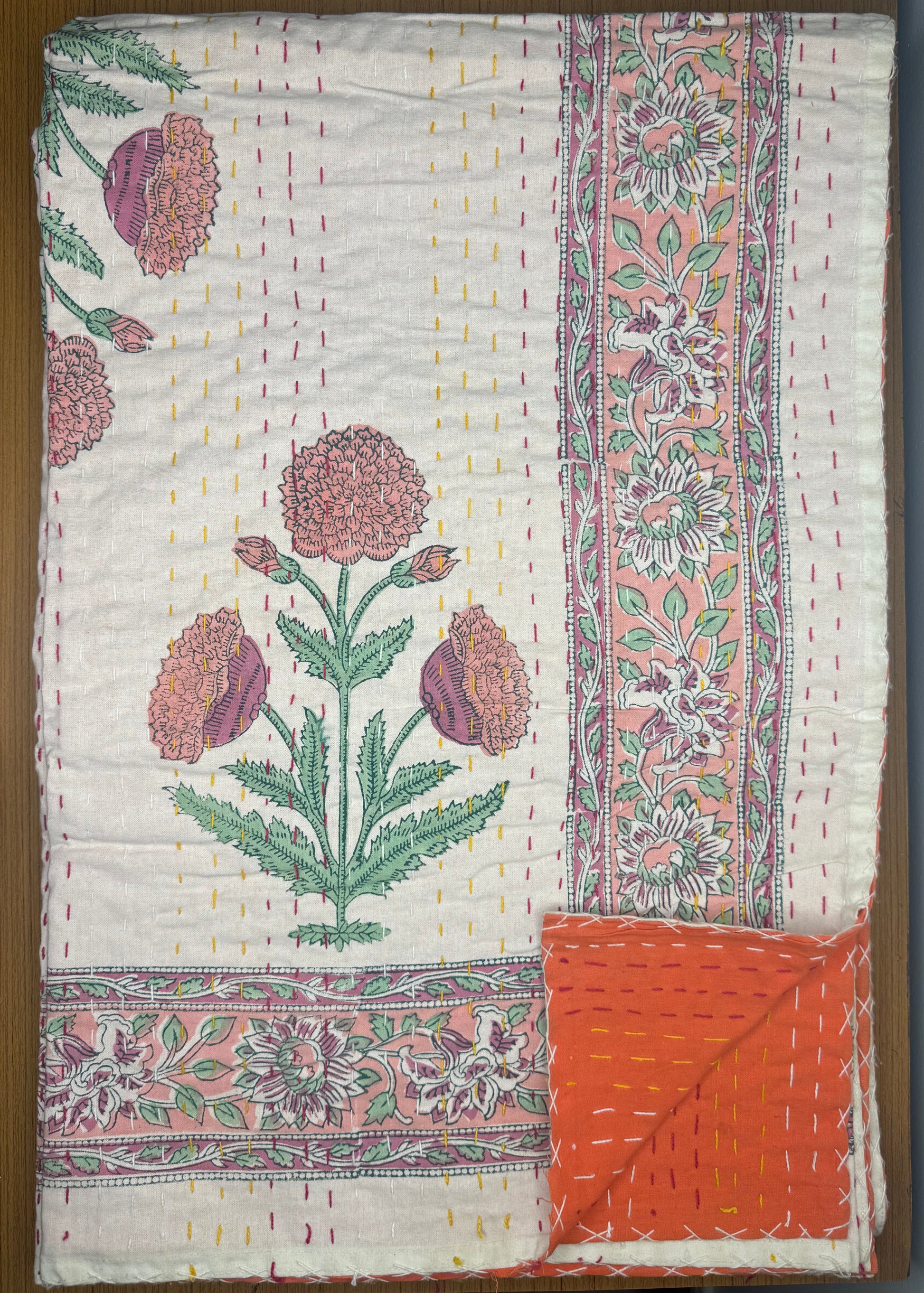 Floral patterned quilt on a wooden surface