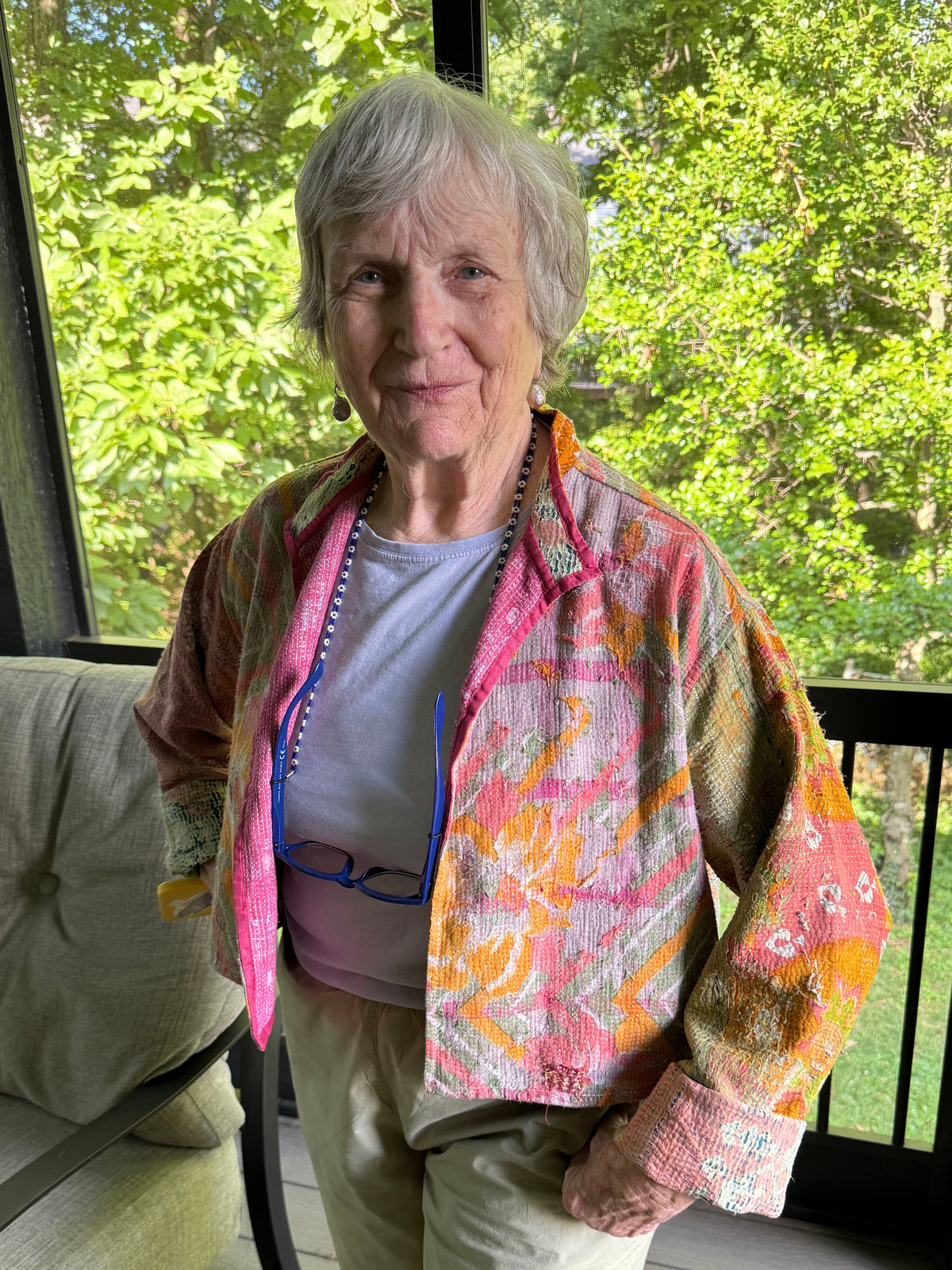 Person wearing a colorful patterned jacket with trees in the background
