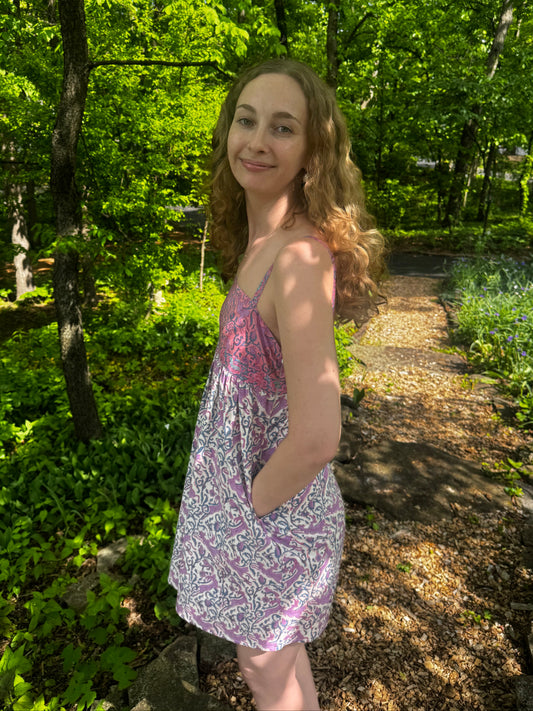 Woman in a patterned dress standing in a forest