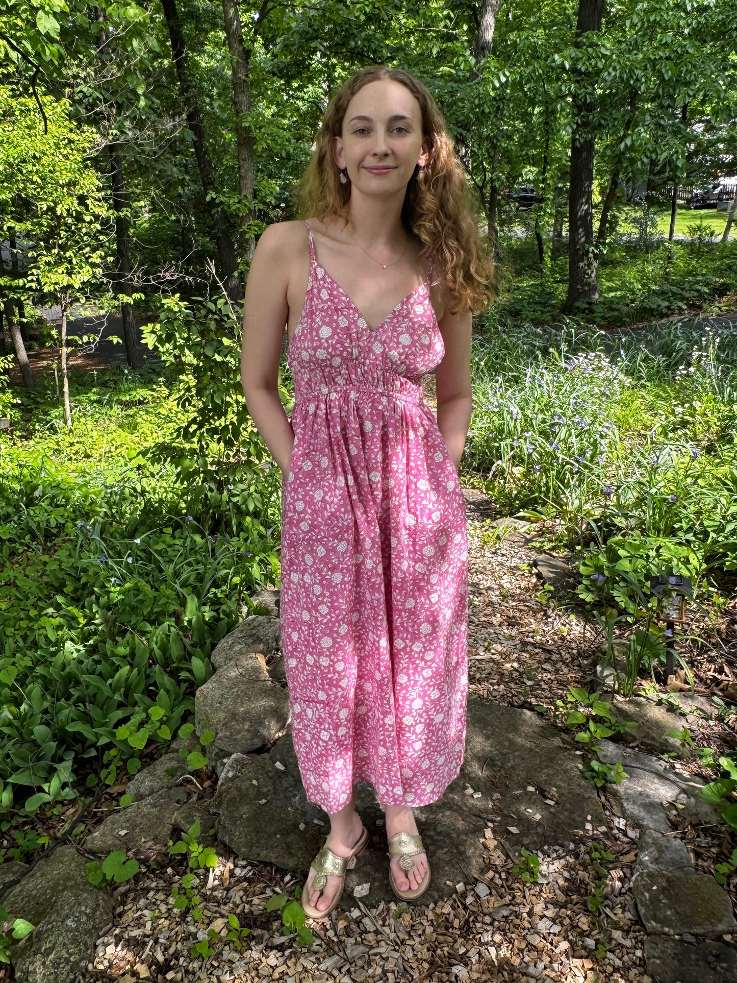 Woman in a pink dress standing in a forest
