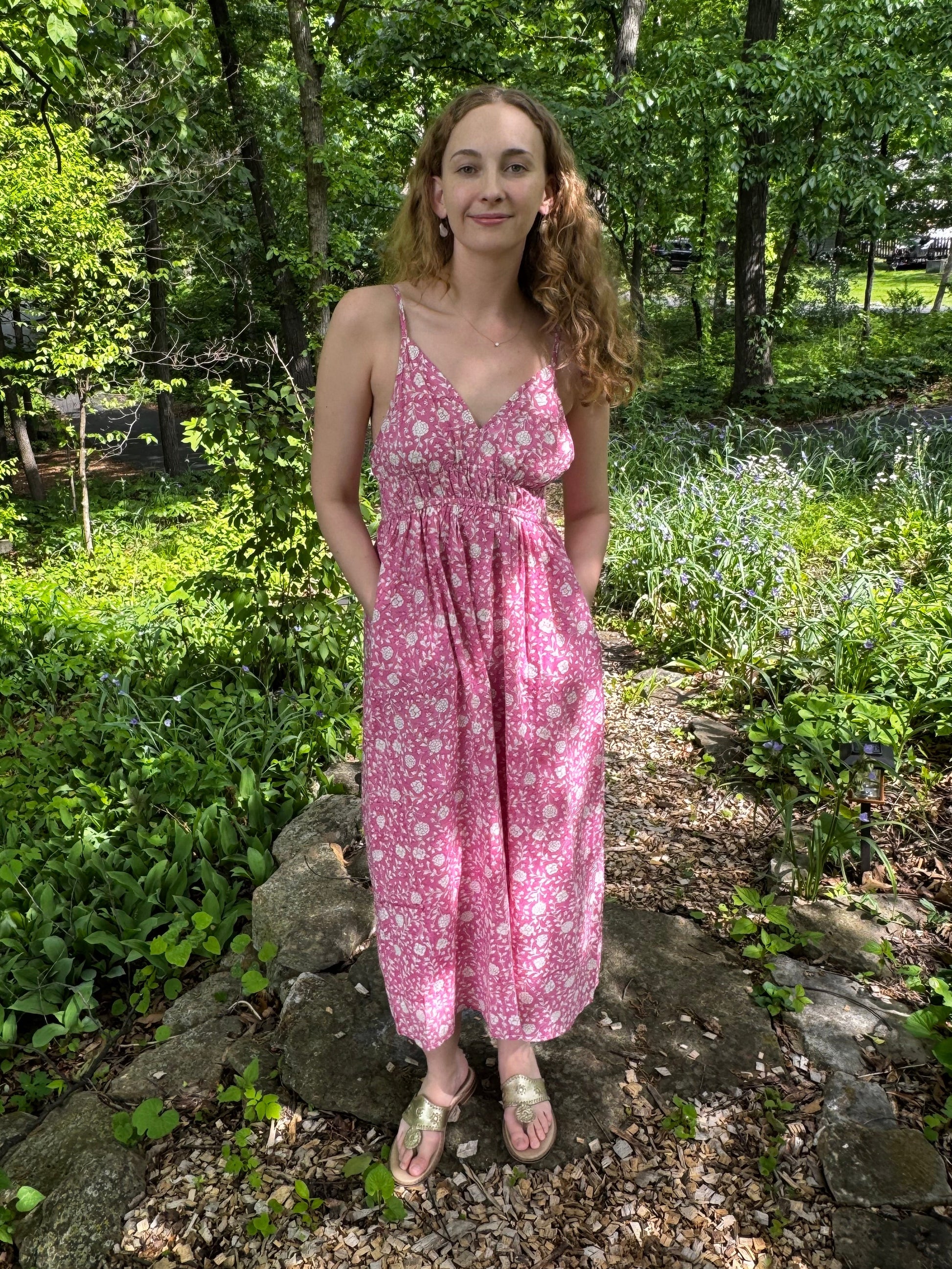 Woman in a pink dress standing in a forest