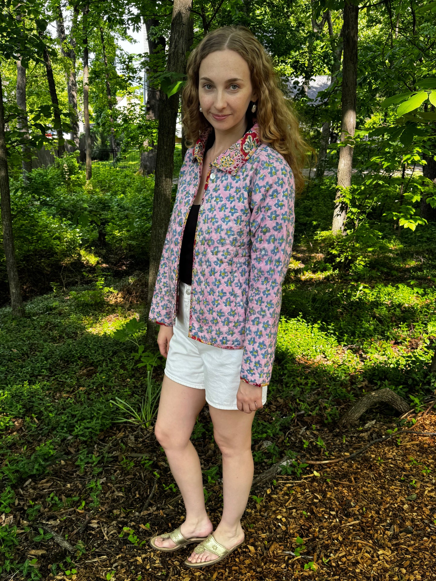 Person standing in a forest with greenery around