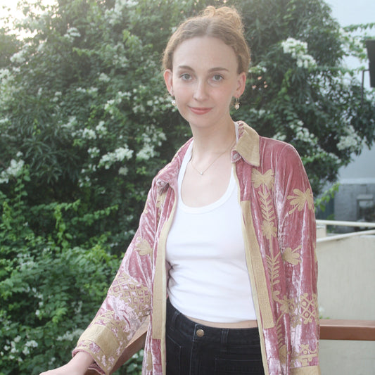 Woman wearing a traditional outfit with a floral pattern in an outdoor setting