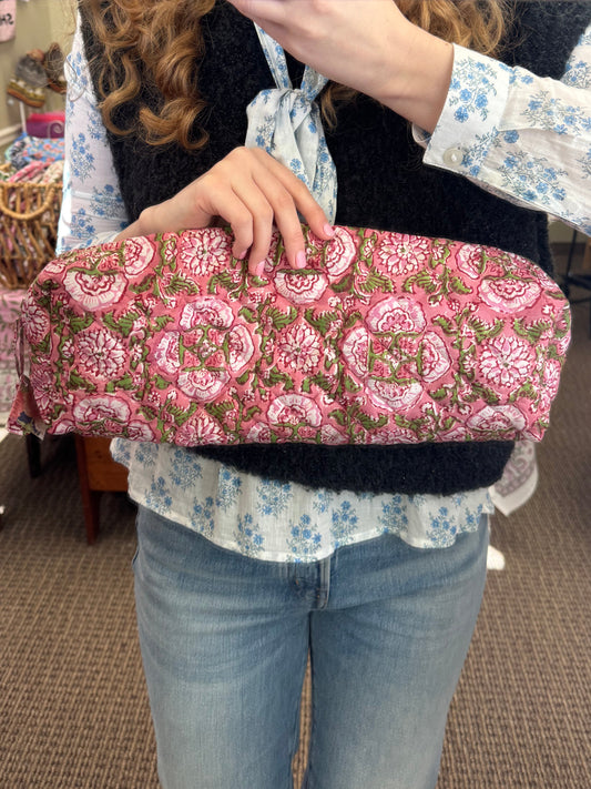 Person holding a pink and green patterned bag in a store setting