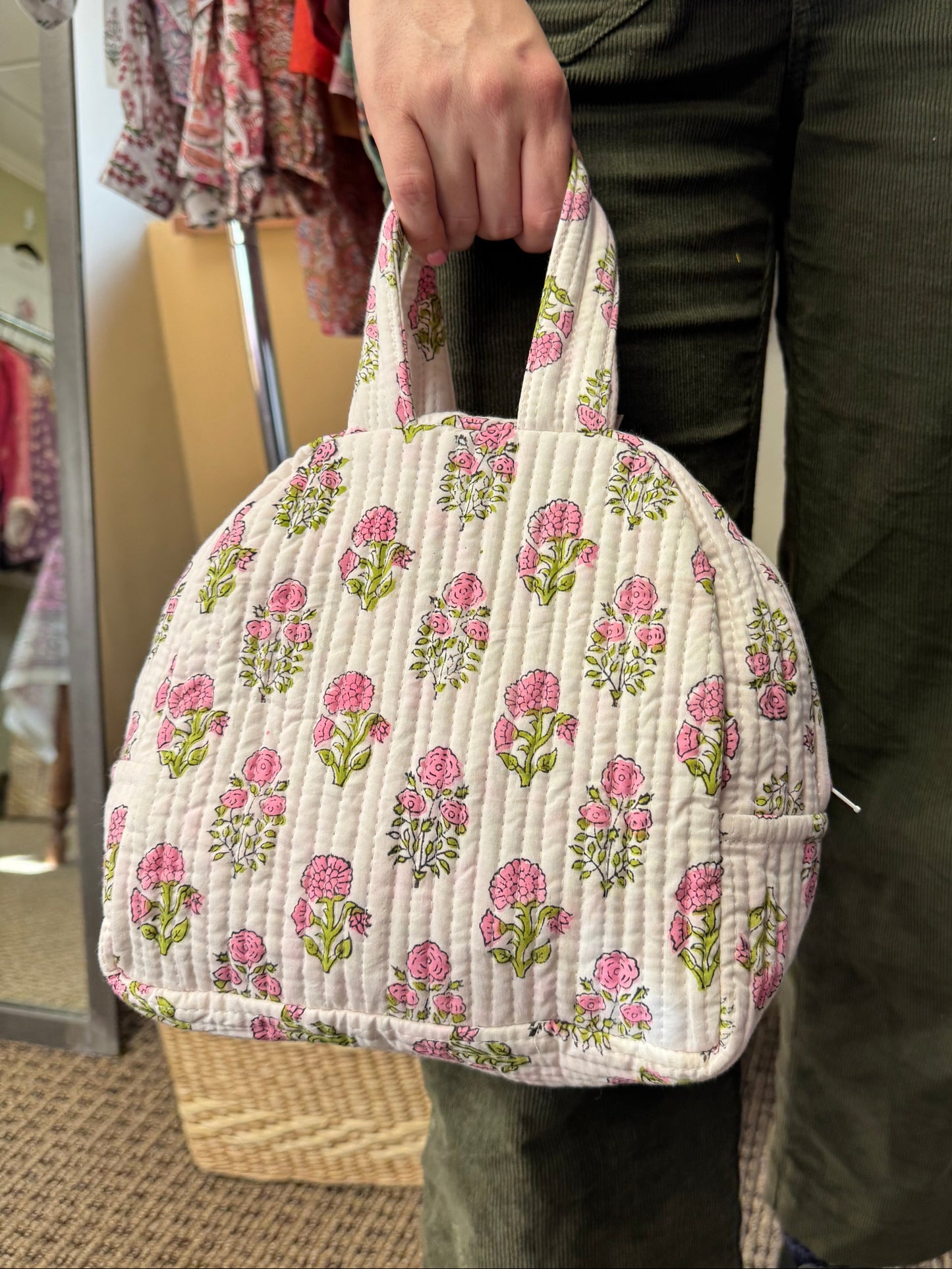 Floral-patterned fabric held by a person with a blurred background